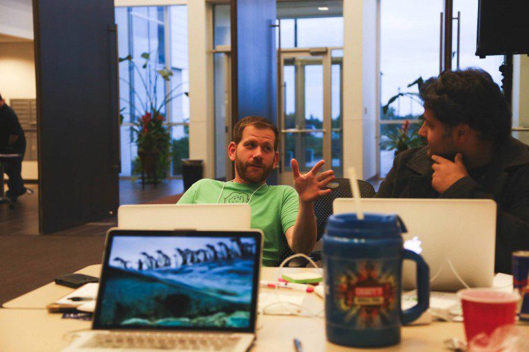 Chief Relationship Officer, David Tominsky, gesticulates in conversation from a reclined position at his desk