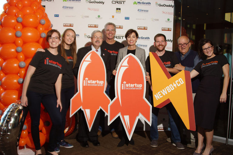 NewBoCo staff poses with rocketship and lightning bolt cutouts (NewBoCo's icons) at an event with the Iowa Lieutenant Governor in 2016