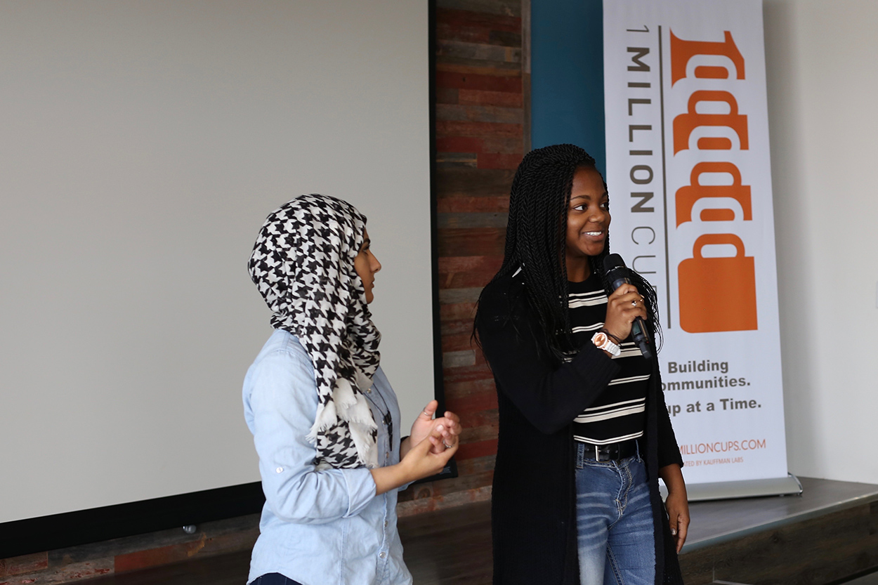 Two high school students present at a 1 Million Cups event