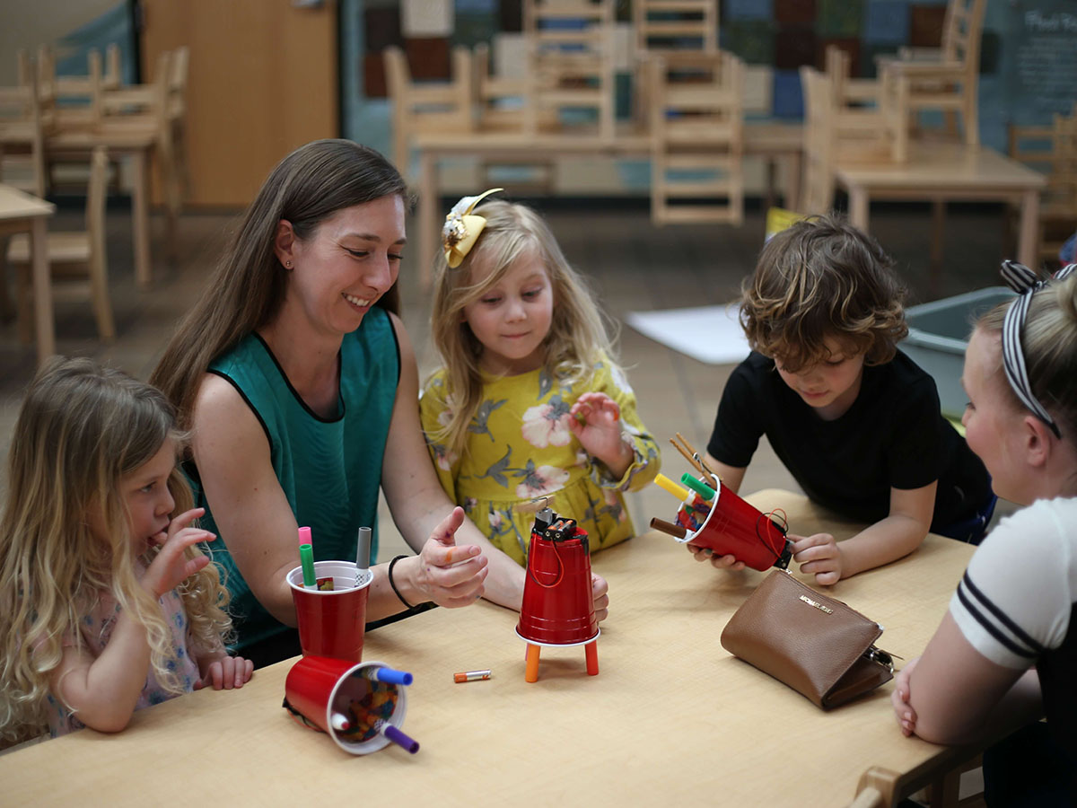 A NewBoCo instructor guides kindergarteners through a Tiny Techies activity building devices using markers and plastic cups