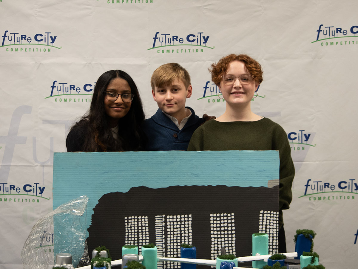 3 Future City Iowa winners pose and smile behind their city diorama