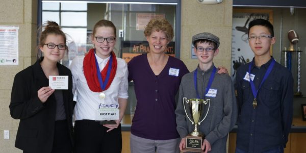 5 middle schoolers pose with their Future City regional competition champion trophy.