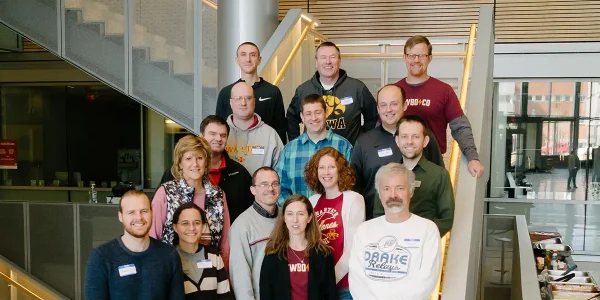 15 Code.org teachers and facilitators pose on a stairwell